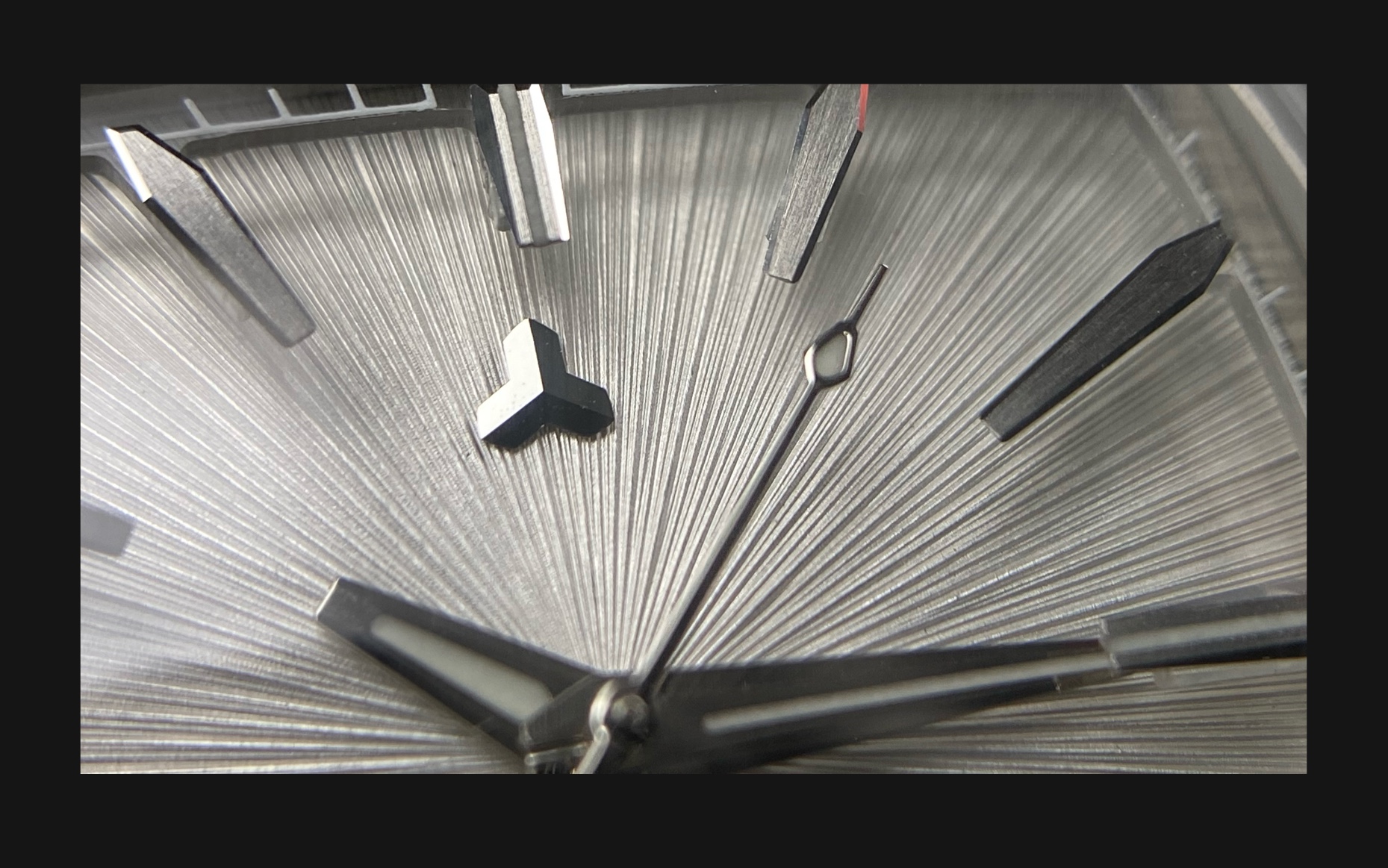 Flux Watch in Silverstone, macro shot focusing on the silver dial and sharp silver hour markers